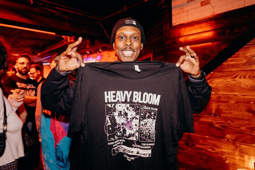 a fan buys a heavy bloom t shirt from the merch table - photo by Conner Yi