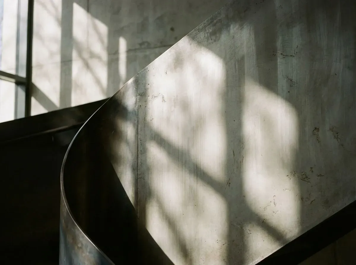 An abstract photograph showcasing the interplay of light and shadow on a sleek, modern architectural surface.